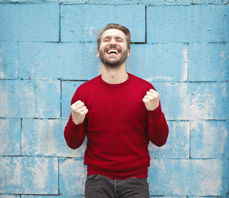 holiday stress. Young man with beard and red sweater smiling and happy. 